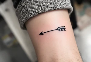 A sleek black ink arrow with a delicate gold accent running along its shaft, symbolizing elegance and direction. tattoo idea