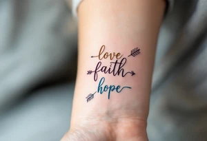 "Love" in dusty rose pink, "Faith" in antique gold, and "Hope" in sky blue, connected by a fine black arrow. tattoo idea