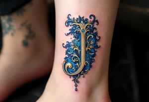 Ornate gold "J" with baroque-style filigree details and royal blue shading. tattoo idea