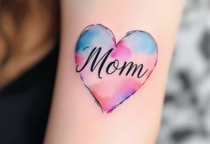 A watercolor heart in pink and blue with the word “Mom” scripted across it in elegant cursive. tattoo idea