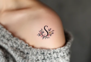 A minimalist black "S" outlined with fine-line flowers in soft pastel tones on finger. tattoo idea