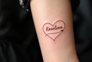 A dotted-line heart in red ink with a tiny plane drawing a trail spelling Karolína. tattoo idea