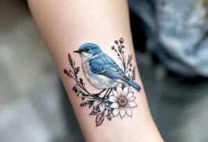 Puffy bluebird surrounded by wild flowers tattoo idea