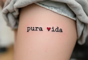 Tiny “Pura Vida” in typewriter font with a single delicate red heart replacing the dot on the “i.” tattoo idea
