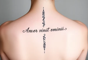 Amor vincit omnia vertically down the middle of the spine in script tattoo idea