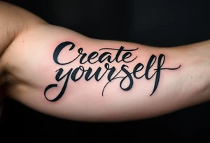 “Create yourself” in graphite black script, with geometric shapes building from the letters in cool grays tattoo idea