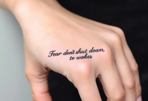 "Fear doesn’t shut you down, it wakes you up" engraved in an elegant script, surrounded by subtle abstract smoke tattoo idea