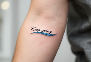 “Keep going” in sleek gray cursive, underlined with a cool blue wave. tattoo idea