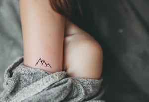 A pair of minimalist black and blue mountain peaks, one tattooed on the one´s forearm and the matching smaller version on the cother tattoo idea