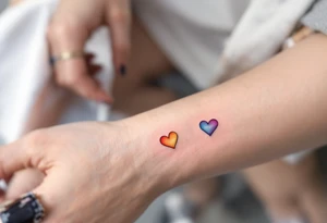 Tiny matching rainbow hearts behind each ear to honor love in every shade. tattoo idea