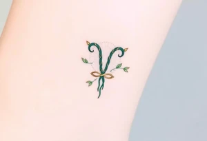 A minimalist Virgo glyph made of intertwining vines, in an elegant dark green and gold gradient tattoo idea