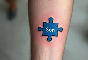 A puzzle piece in bright blue labeled “Son,” fitted perfectly into a black outline of a heart. tattoo idea