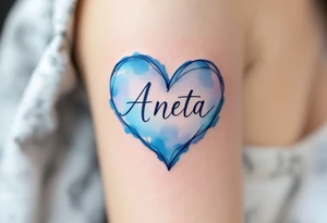 A watercolor-style heart in pastel blue with Aneta written in elegant lettering. tattoo idea