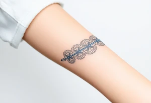 A lace ribbon around the forearm, with fine embroidery-inspired details tattoo idea