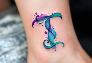A watercolor-style "T" in shades of turquoise and purple, blending like paint strokes. tattoo idea