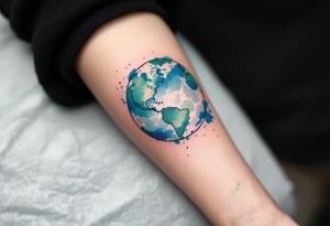 A vibrant watercolor Earth tattoo in shades of blue and green splashes across the forearm like a painter’s globe. tattoo idea