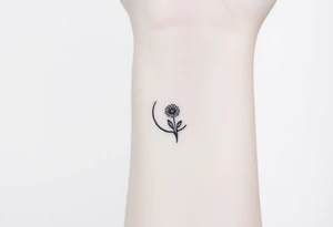 Small black and white tattoo waxing crescent moon with small Daisy birth flower and tiny Leo gliph tattoo idea