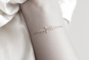 A thin, delicate gold band with intricate white filigree engravings, symbolizing timeless elegance and devotion. tattoo idea