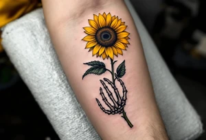 A skeleton hand holding a dying yellow sunflower, quote "memento mori" in thin, winding black cursive along the stem. tattoo idea