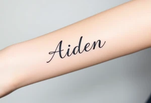 The name Aiden this and bold cursive tattoo idea