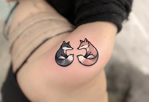 A black and white yin-yang formed by curled foxes on each partners shoulder. tattoo idea