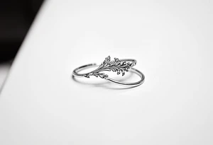 A thin, delicate gold ring with intricate white filigree engravings, symbolizing timeless elegance and devotion. tattoo idea