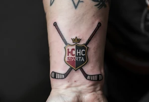 Two crossed hockey sticks with the HC Sparta crest in deep red and yellow centered on the wrist. tattoo idea