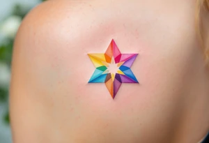 A rainbow-colored eight-pointed star tattoo celebrates inclusivity and universal love on shoulderblade tattoo idea