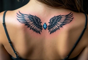 A pair of black ink wings cradling a small, blue gem with the son’s initials KS inside. tattoo idea