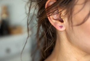 Tiny rainbow hearts behind each ear to honor love in every shade. tattoo idea