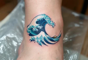 A turquoise wave crashes in delicate linework on the ankle, accented with silver highlights. tattoo idea