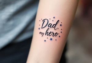 Bold black script saying “Dad, my hero” framed by navy blue stars. tattoo idea