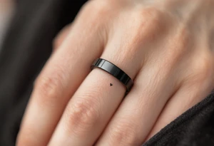 A minimalist black titanium band with a subtle engraved heartbeat line, capturing the rhythm of love. tattoo idea