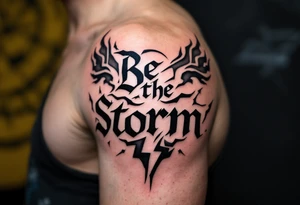 "Be the Storm" in sharp serif font, black ink with storm cloud shading and lightning bolt details in gray. tattoo idea