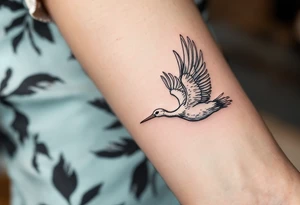 A stork in flight with a blue or pink bundle symbolizes birth and a mother’s journey beginning. tattoo idea