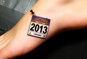 Safety pins through the skin attaching a half marathon racing bib with 2013 and purple and gold accents with “I don’t care, I love it” around the outside tattoo idea