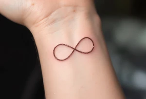 A thin, minimalist infinity outline in rose gold, with tiny white sparkles accenting the curves. tattoo idea