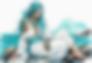 An undine with turquois scales wearing a white robe, sitting on rocks by the ocean tattoo idea