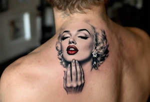 Tattoo of Marilyn blowing a kiss in grayscale with a vivid red heart-shaped kiss mark. tattoo idea