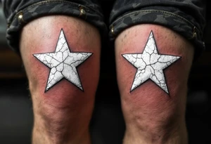 Distressed white stars with cracked textures, centered on each kneecap, resembling aged paint on concrete for a rugged look. tattoo idea
