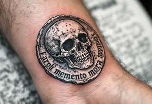 A Roman coin with a skull embossed in silver, the inscription "memento mori" in rough gray Latin lettering beneath it. tattoo idea