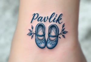 Pavlík written above a tiny pair of baby shoes in dusty blue. tattoo idea