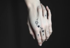 tattoo on back of hand and around fingers that includes stars and had a cool design made of lines tattoo idea