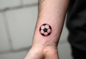 A simple red soccer ball icon on the wrist for a subtle, bold statement. tattoo idea