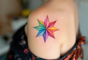 A rainbow-colored eight-pointed star tattoo celebrates inclusivity and universal love on shoulderblade tattoo idea
