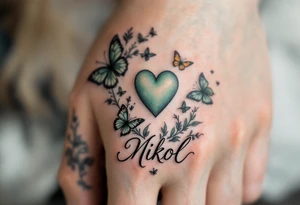 A pastel green heart with butterflies and Nikol written in elegant lowercase. tattoo idea