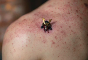 A samurai helmet (kabuto) in deep black steel with crimson cords and gold trim. tattoo idea