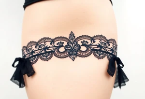 A negative space garter tattoo design, where the lace details are subtly left out tattoo idea