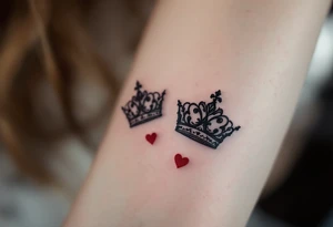 Ornate filigree-style black crowns with small deep red heart designs beneath each. tattoo idea