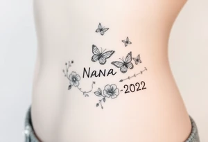 flowers and butterflies with the name “NANA” and the date “1954-2022” mixed all together on the side of the rib cage tattoo idea